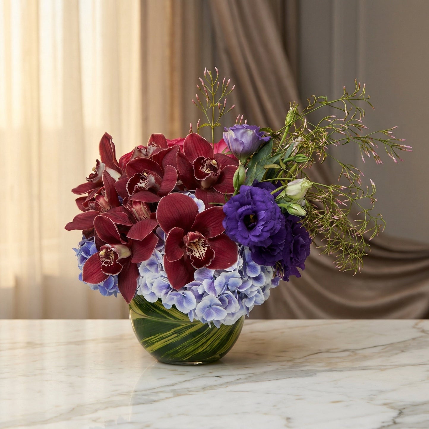 Burgundy orchids, purple lisianthus, and blue hydrangeas in a green glass vase - TJ Flowers NYC