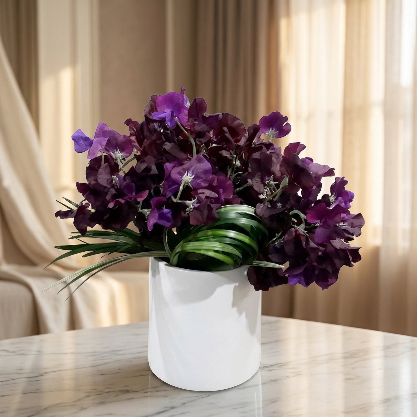 Deep purple sweet pea flowers in a modern white ceramic cylinder vase on a marble table - TJ Flowers NYC