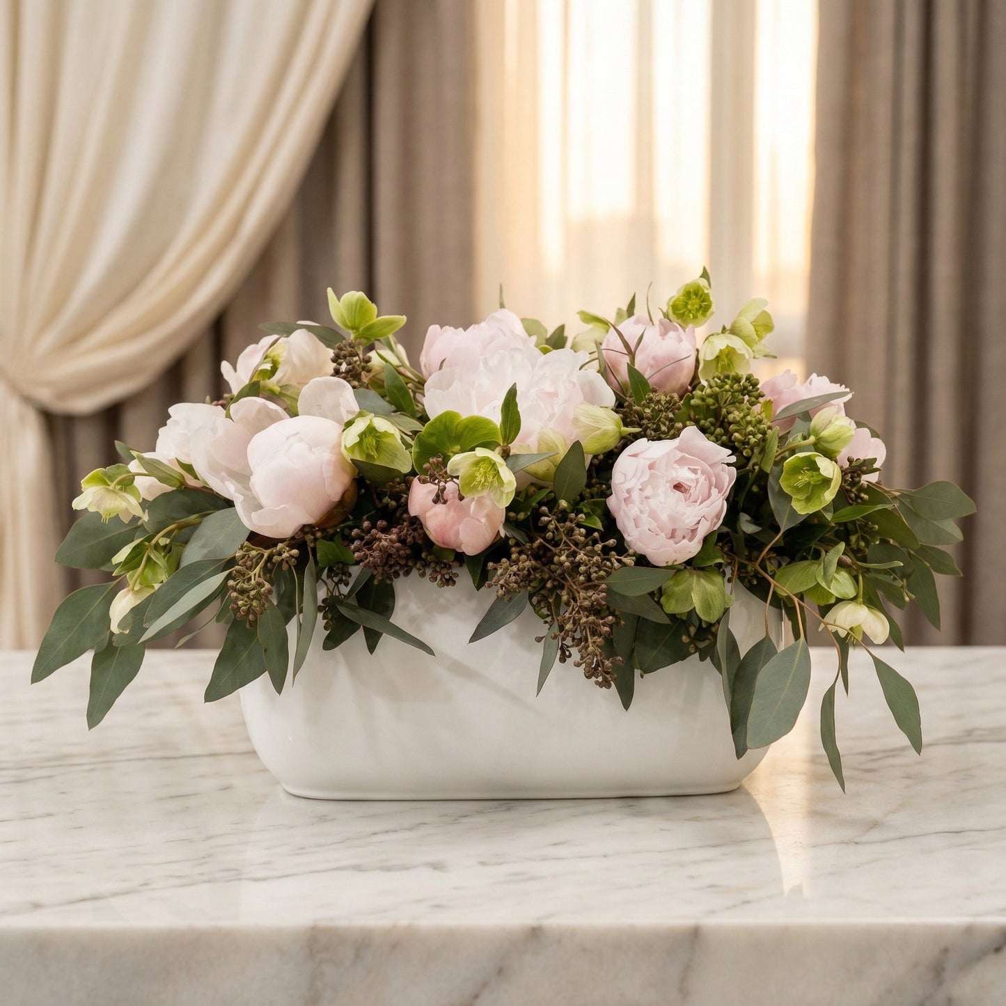 Blush pink peonies and green hellebores in a white ceramic vase on a marble table - TJ Flowers NYC