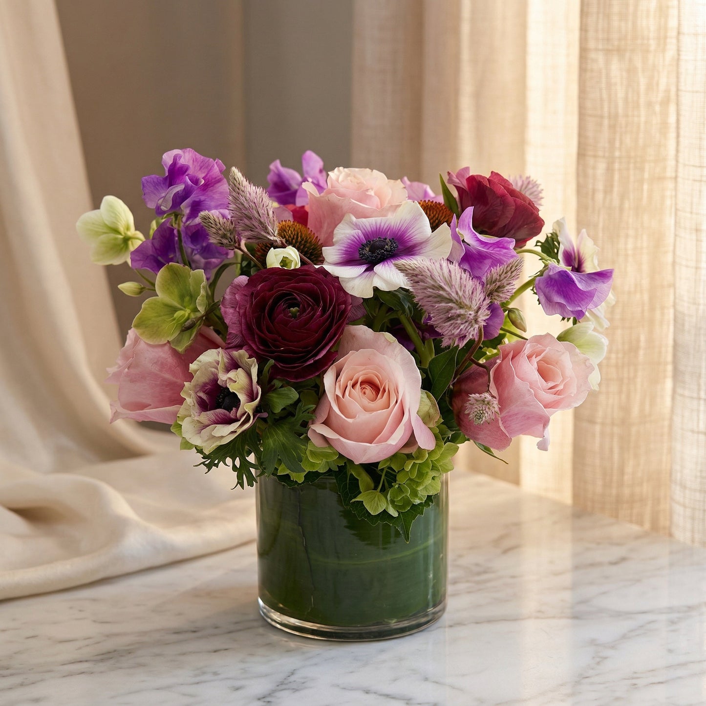 Purple and pink mixed bouquet with roses and anemones in a glass cylinder vase - TJ Flowers NYC