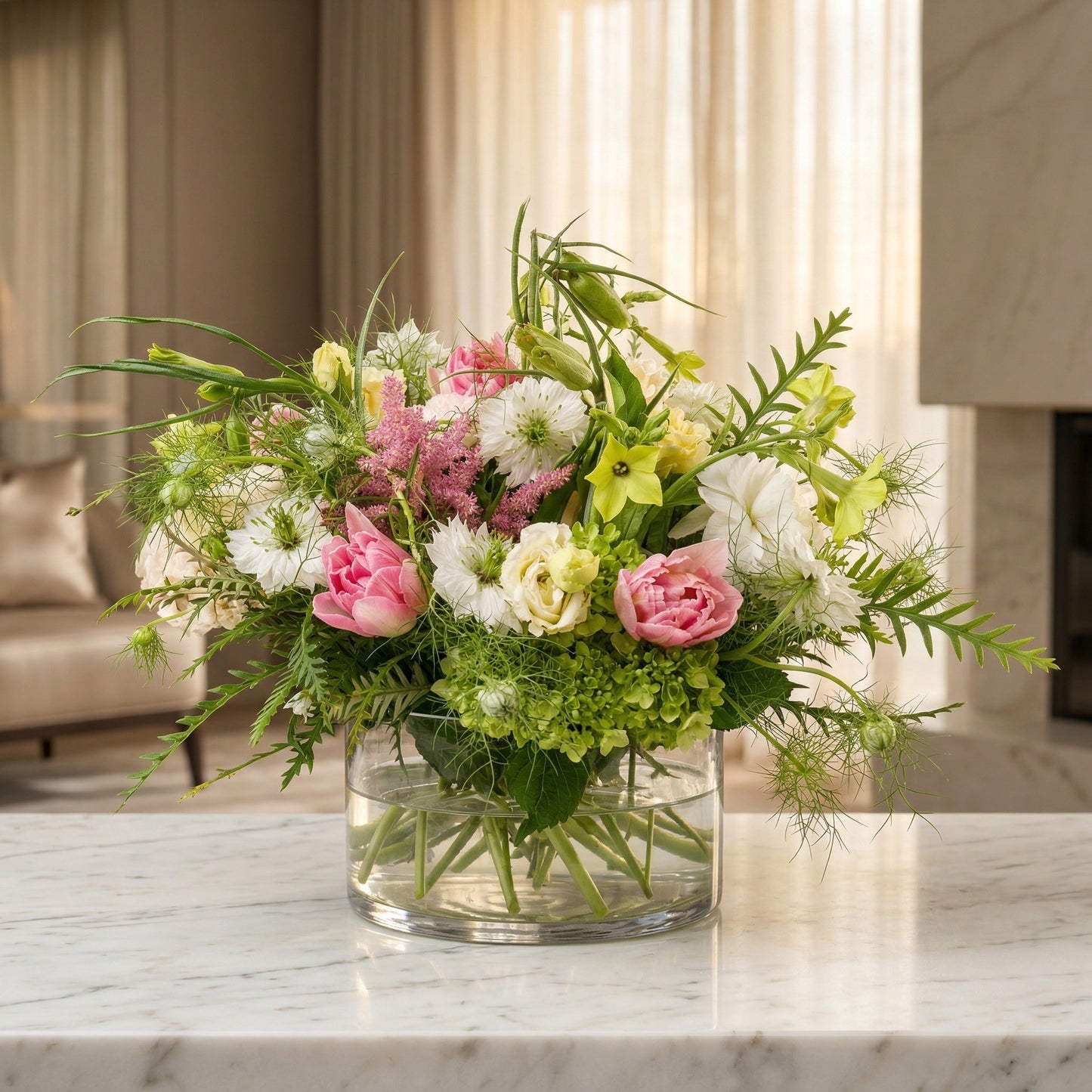 Pastel pink tulips, white nigella, and green hydrangeas in a clear glass cylinder vase - TJ Flowers NYC