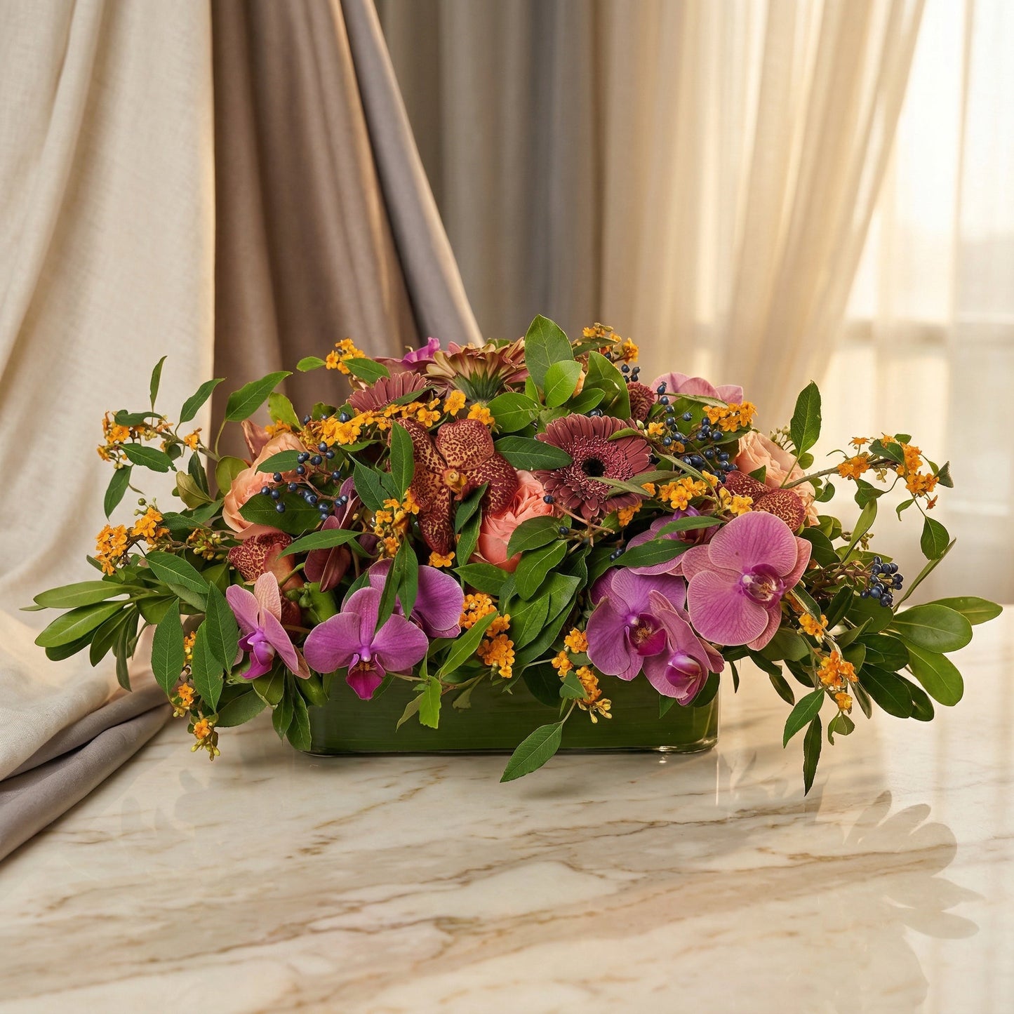 Purple orchids, pink roses, and orange filler flowers in a low glass vase on marble - TJ Flowers NYC
