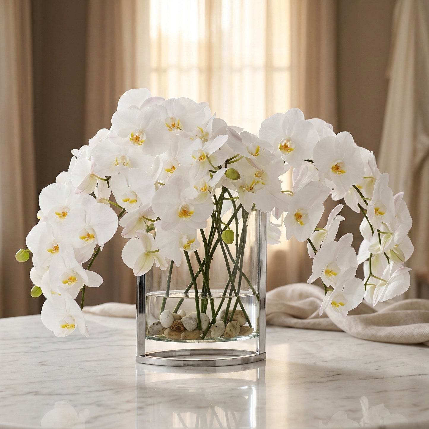 Elegant white phalaenopsis orchids in a modern glass and metal vase with river stones. - TJ Flowers NYC
