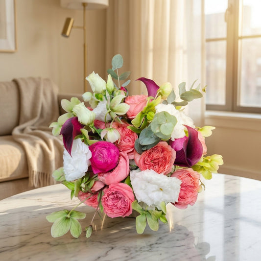 Lush pink, white, and burgundy flower arrangement with roses, ranunculus, and calla lilies in a low vase - TJ Flowers NYC