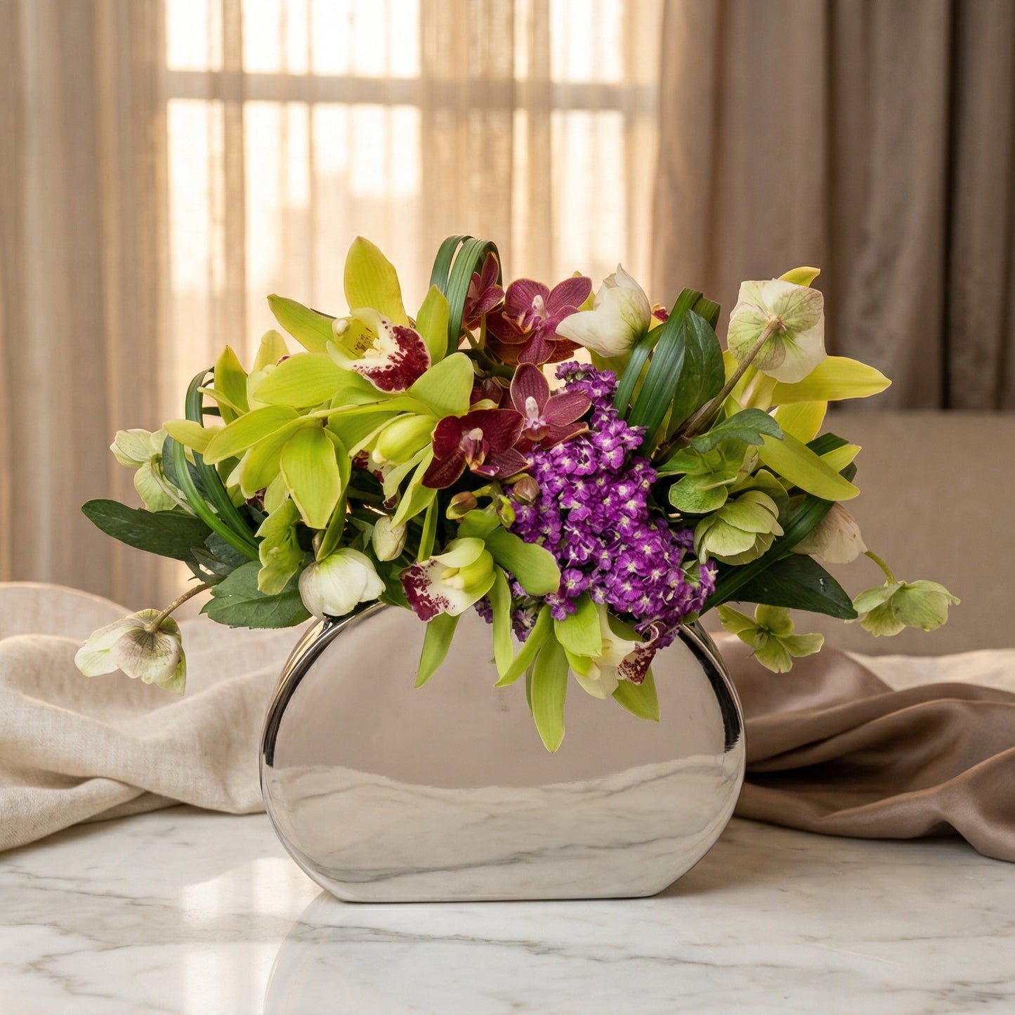 Green and purple orchids with hellebores in a modern silver vase - TJ Flowers NYC