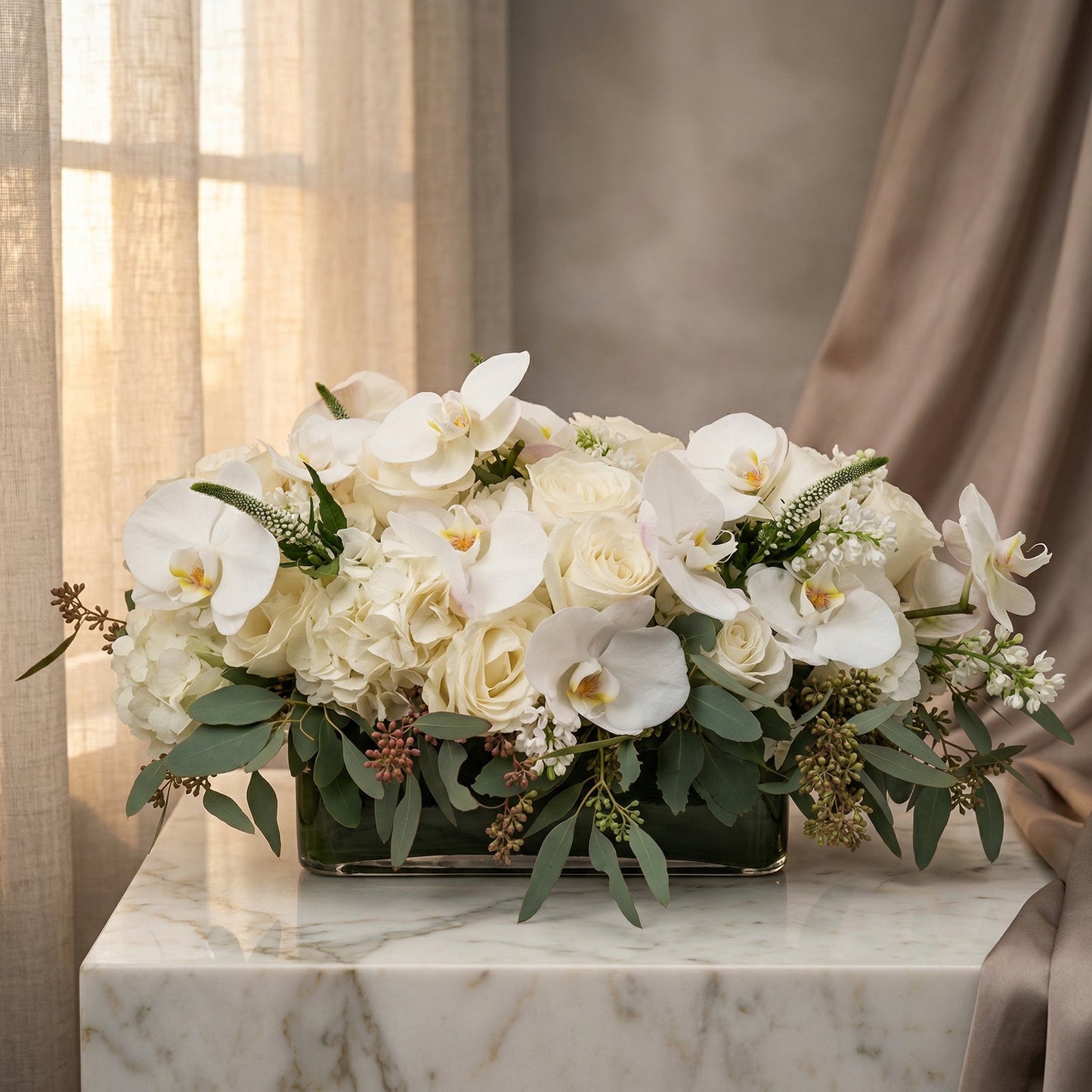 Elegant white phalaenopsis orchids, roses, and hydrangeas in a low glass vase with eucalyptus - TJ Flowers NYC