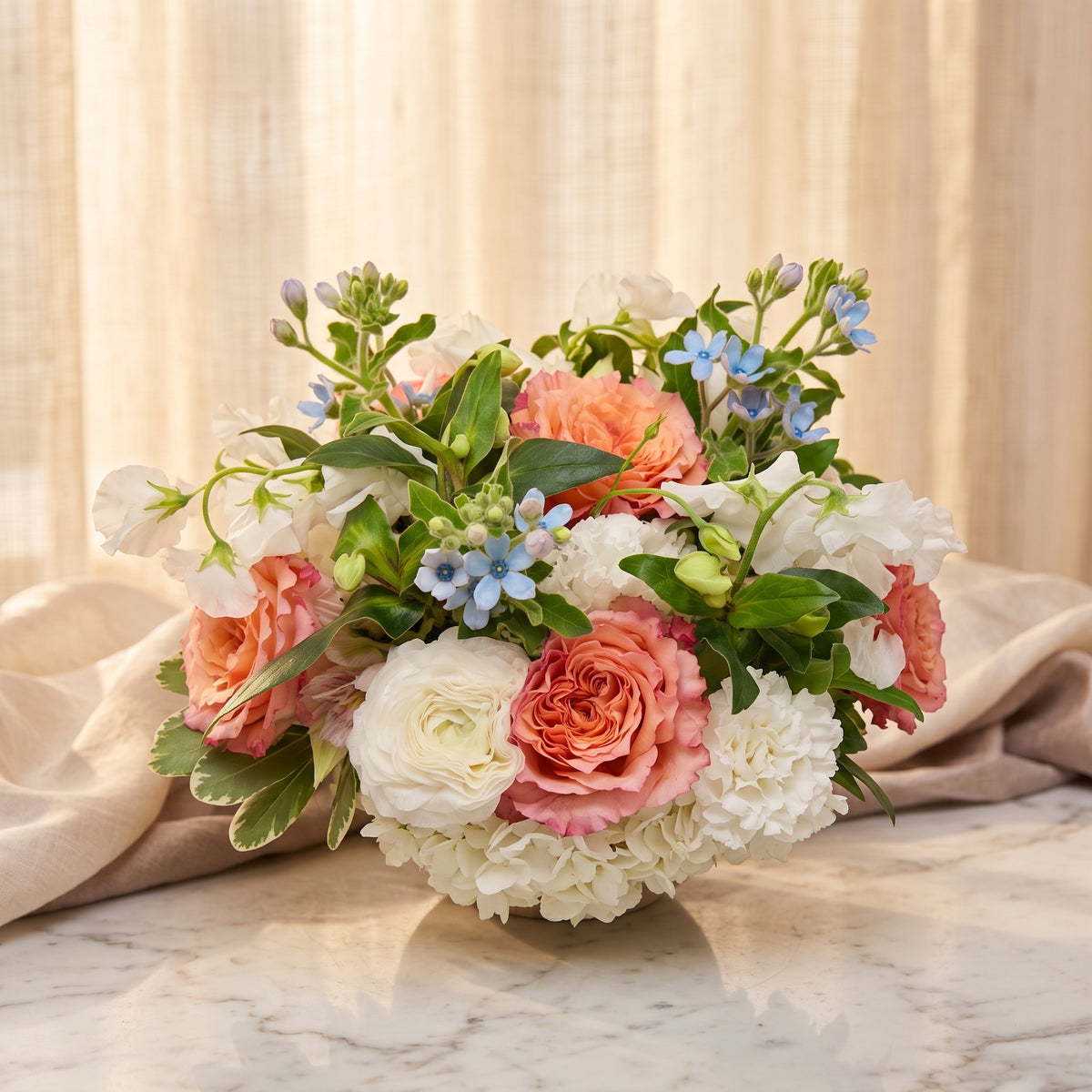Peach garden roses with white ranunculus, white carnations and sky-blue tweedia - TJ Flowers NYC