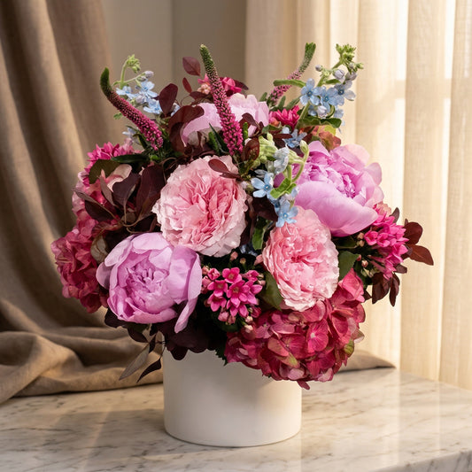 Pink peonies, roses, and hydrangeas with blue accents in a white vase - TJ Flowers NYC
