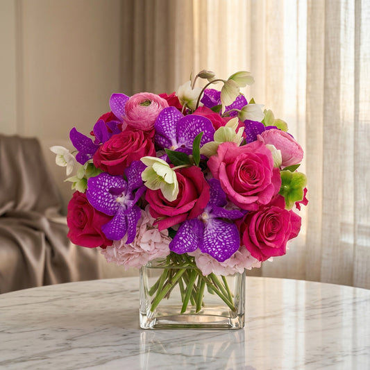 Vibrant pink roses and purple vanda orchids in a clear glass cube vase - TJ Flowers NYC