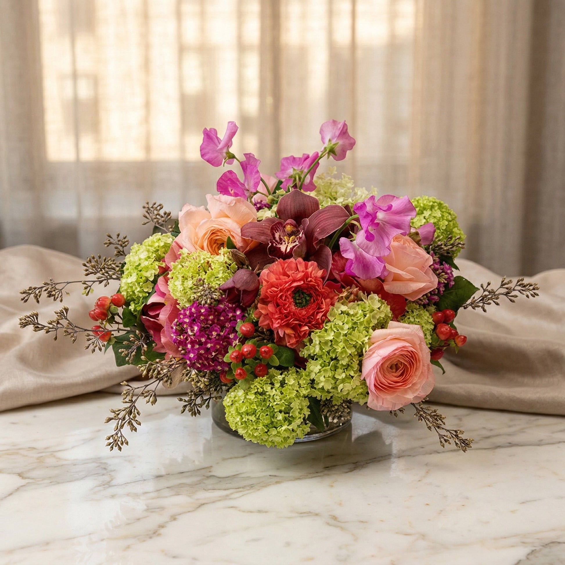 Pastel mixed bouquet with roses, orchids, and green hydrangeas in a glass vase - TJ Flowers NYC