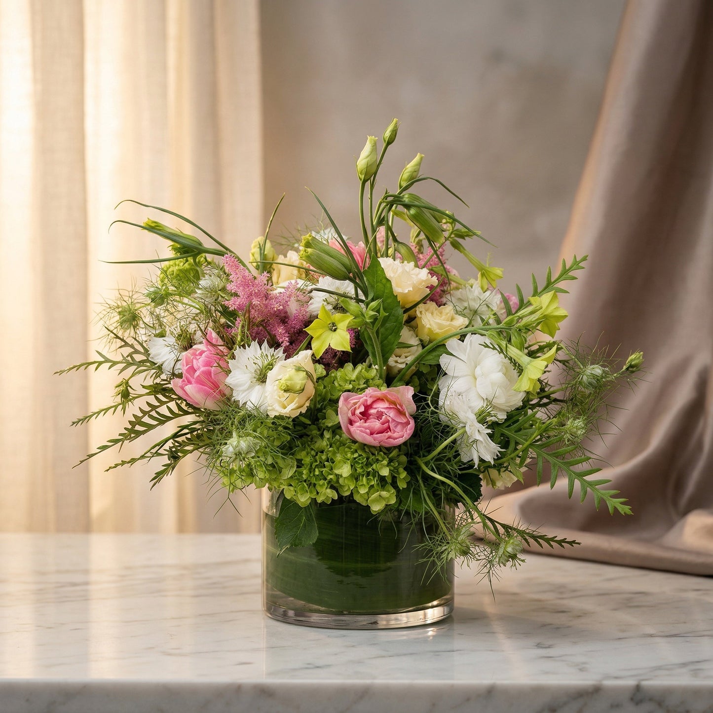 Pastel pink, white, and green flower arrangement with hydrangeas in a clear glass cylinder vase - TJ Flowers NYC
