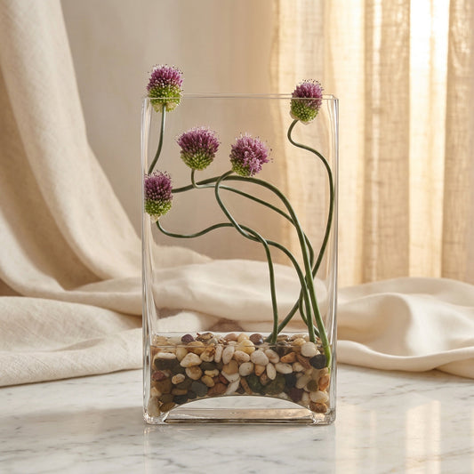 Purple allium flowers in a clear glass vase with river stones - TJ Flowers NYC