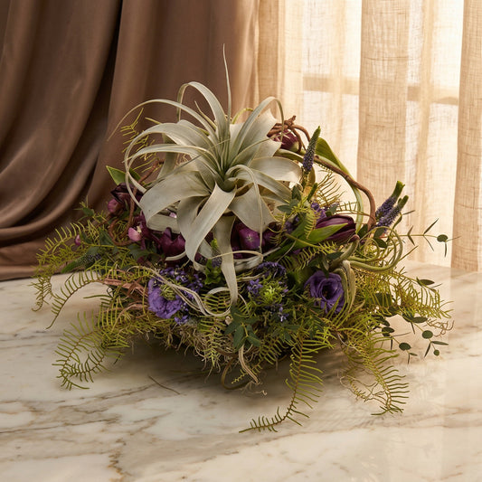 Purple tulips and lisianthus with a large air plant and ferns in a rustic basket - TJ Flowers NYC