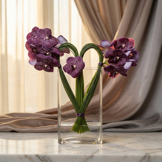 Purple Vanda orchids in a heart shape with green stems in a clear glass vase - TJ Flowers NYC