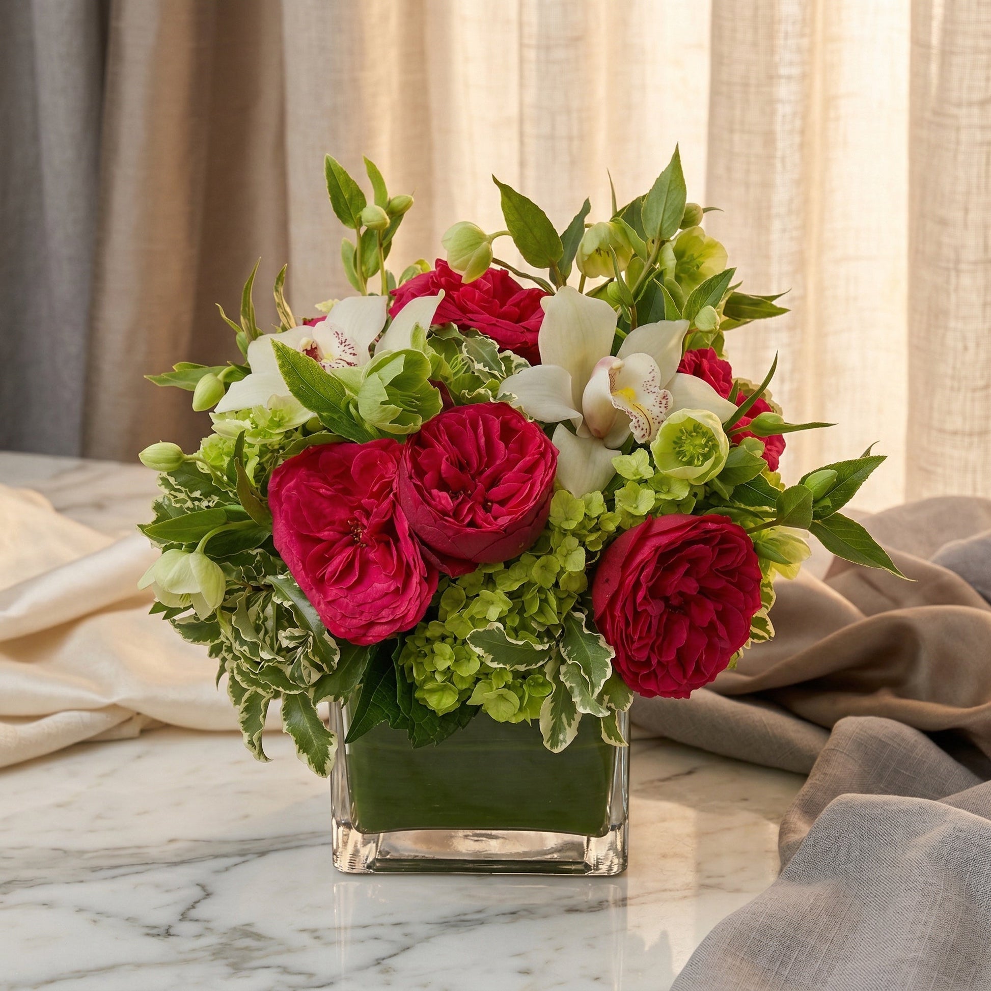 Deep red garden roses, white orchids, and green hydrangeas in a square glass vase - TJ Flowers NYC