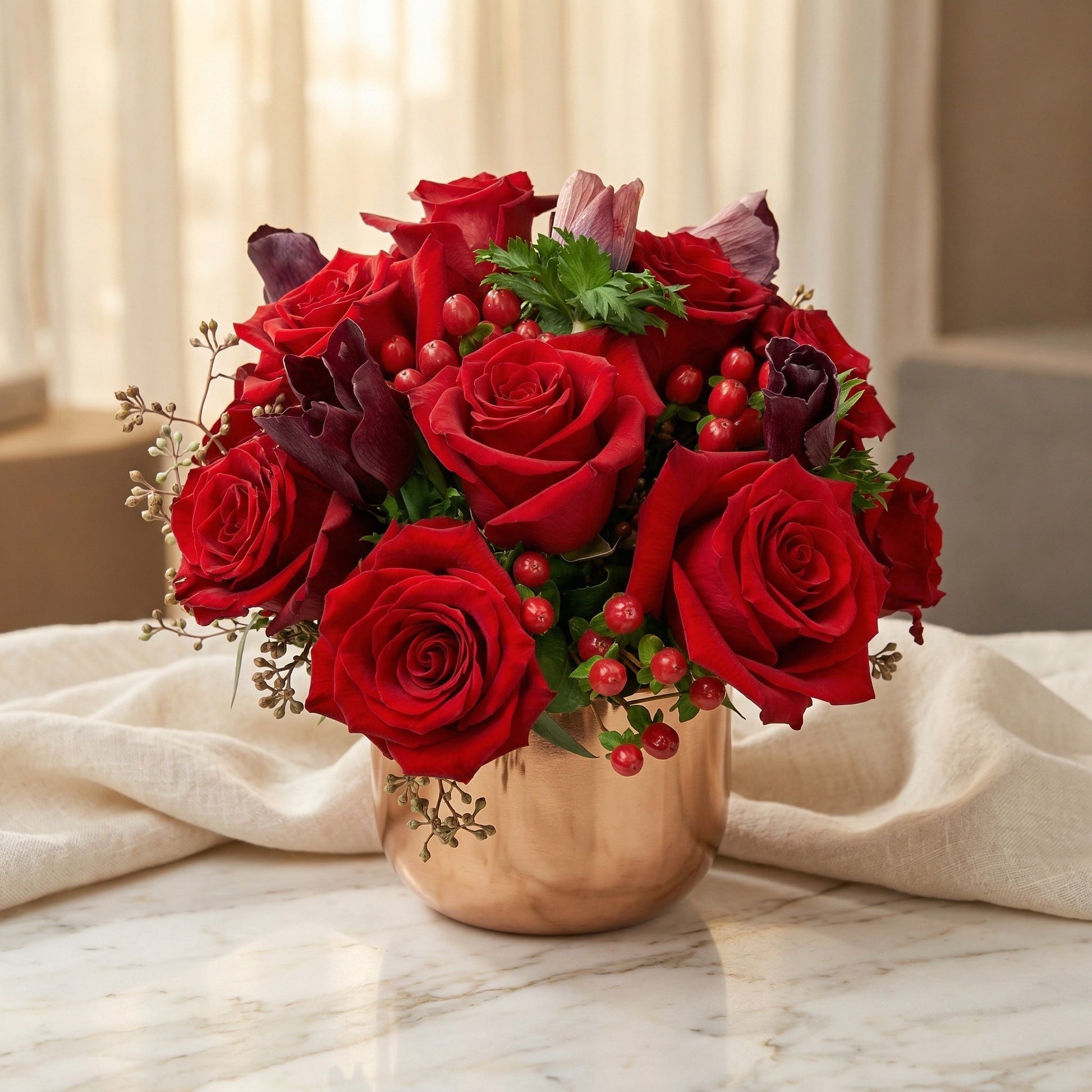Red roses, dark tulips, and berries in a copper vase on a marble table - TJ Flowers NYC
