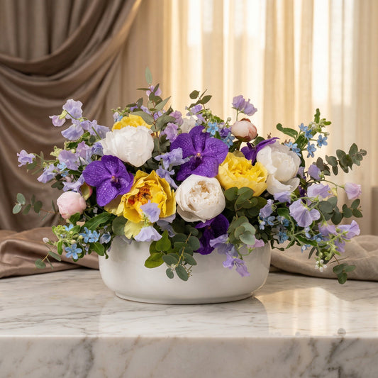 Purple orchids, yellow and white peonies, and blue flowers in a white bowl vase - TJ Flowers NYC