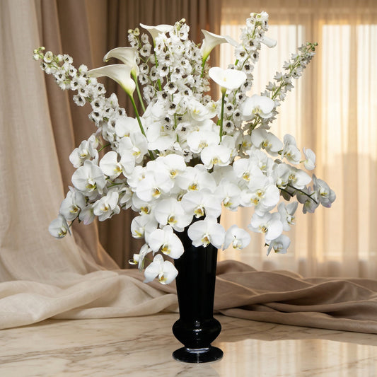 Elegant white phalaenopsis orchids and delphinium in a sleek black vase - TJ Flowers NYC
