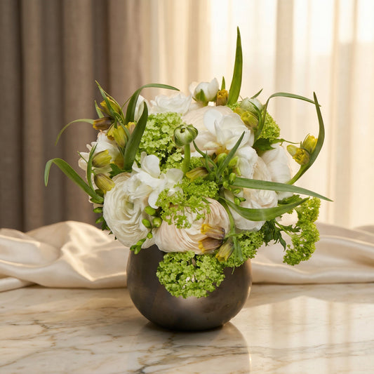 White ranunculus and green viburnum in a dark metallic vase - TJ Flowers NYC