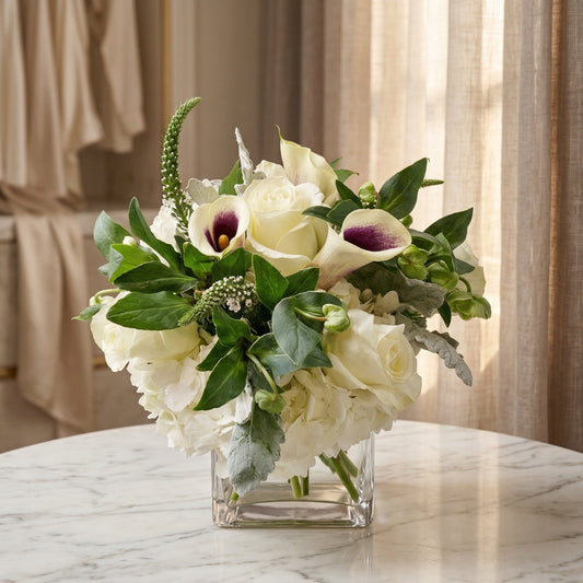 White roses, hydrangeas, and purple-center calla lilies in a square glass vase - TJ Flowers NYC