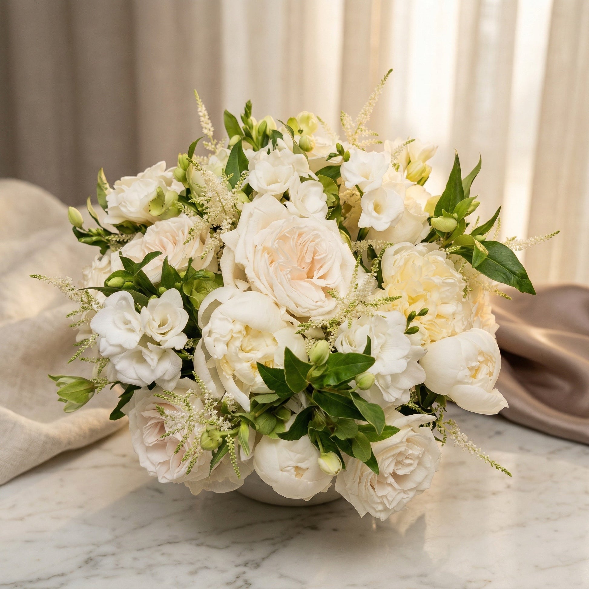 Elegant white rose and peony bouquet with astilbe in a low white vase on marble - TJ Flowers NYC