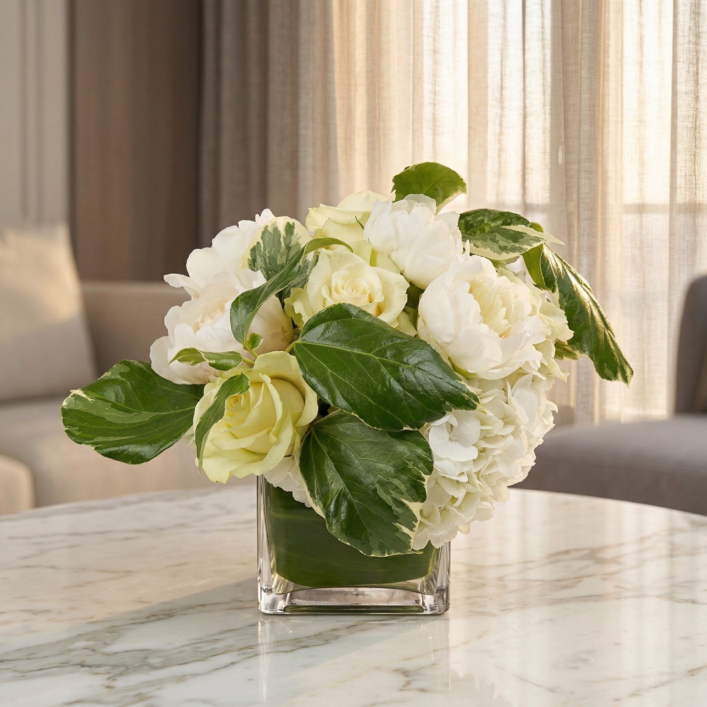 White roses, peonies, and hydrangeas in a square glass vase with variegated leaves - TJ Flowers NYC
