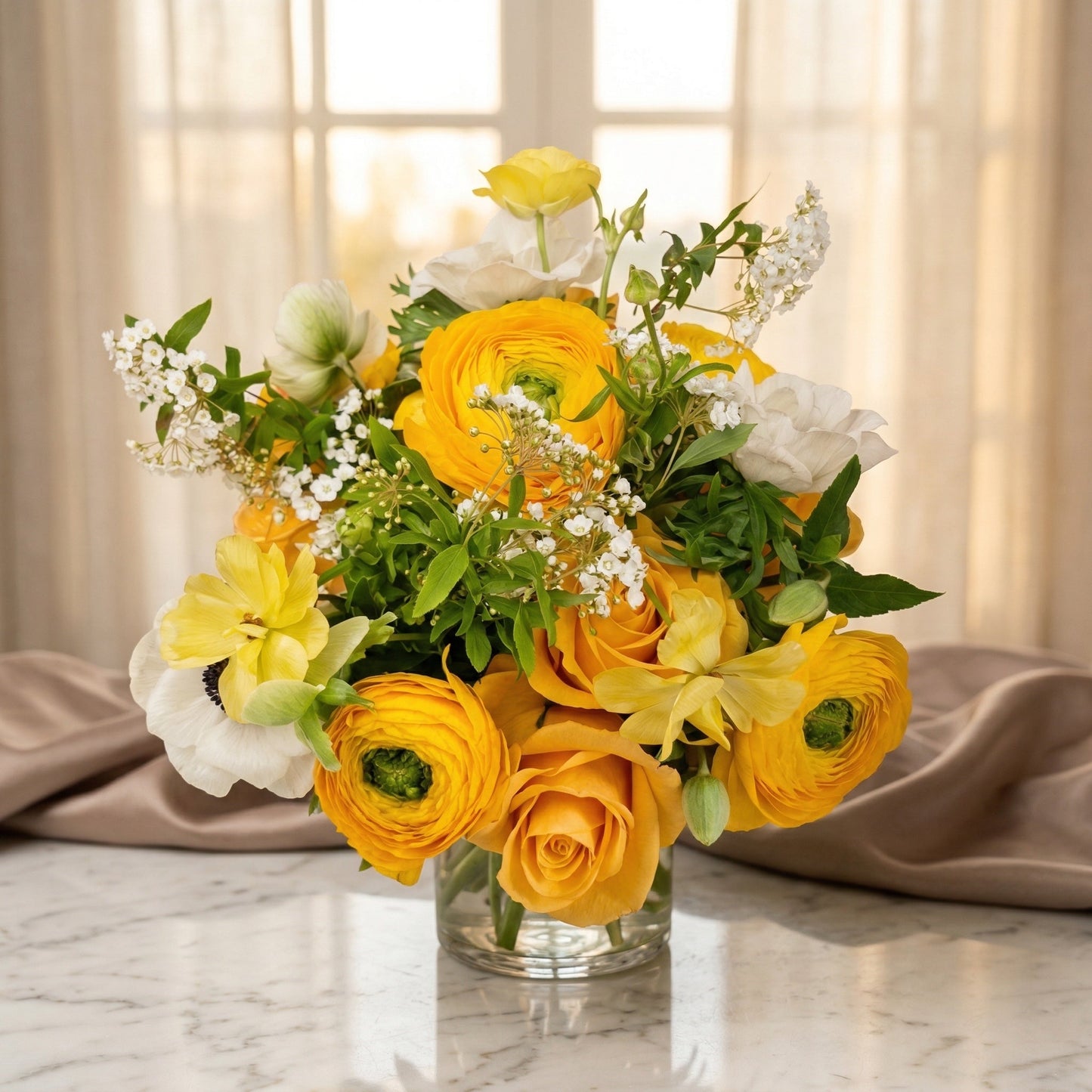 Yellow ranunculus and roses with white anemones in a clear glass vase - TJ Flowers NYC