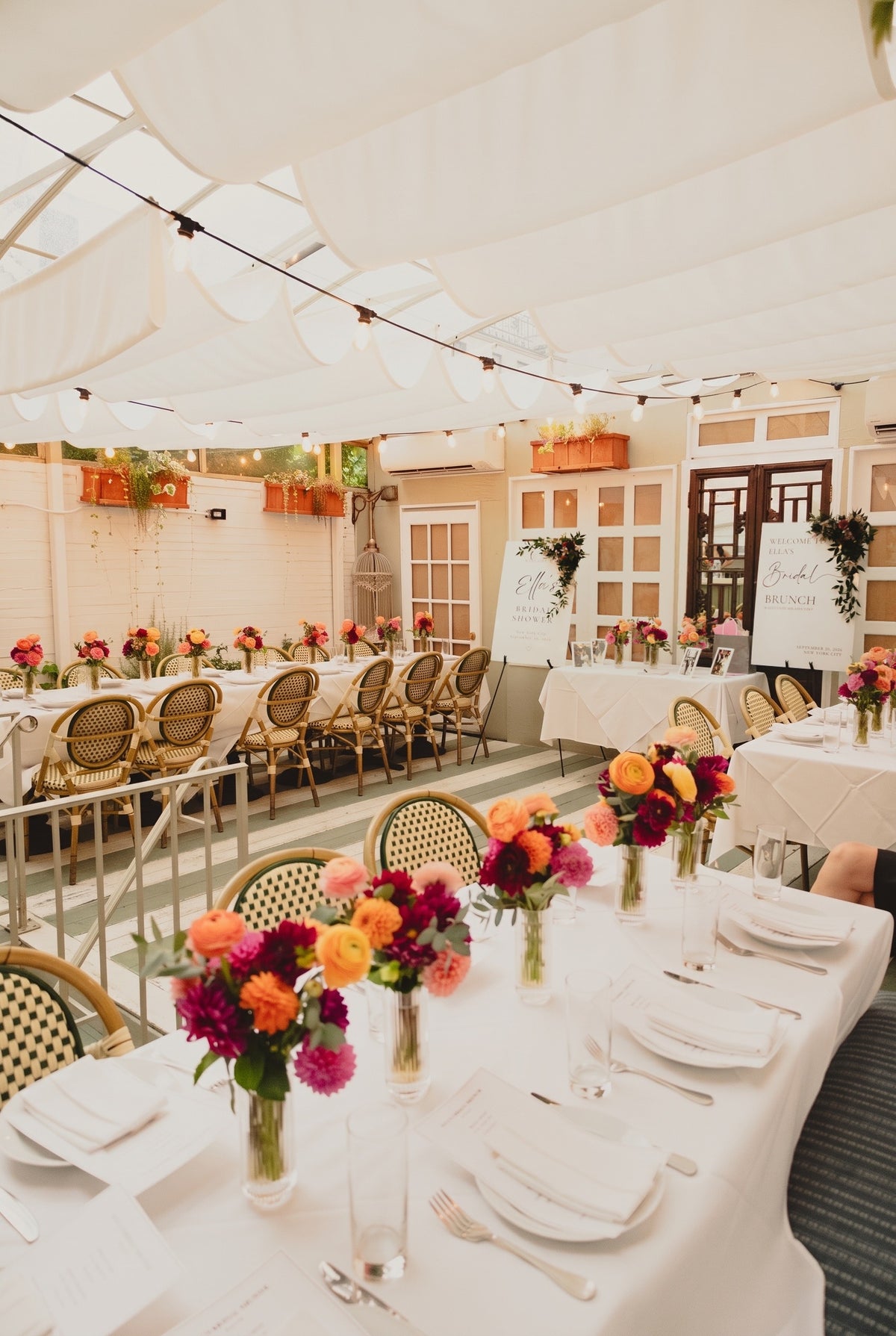 Bridal shower tablescape with dahlia and ranunculus bud-vase centerpieces on a covered garden terrace in NYC - TJ Flowers & Events